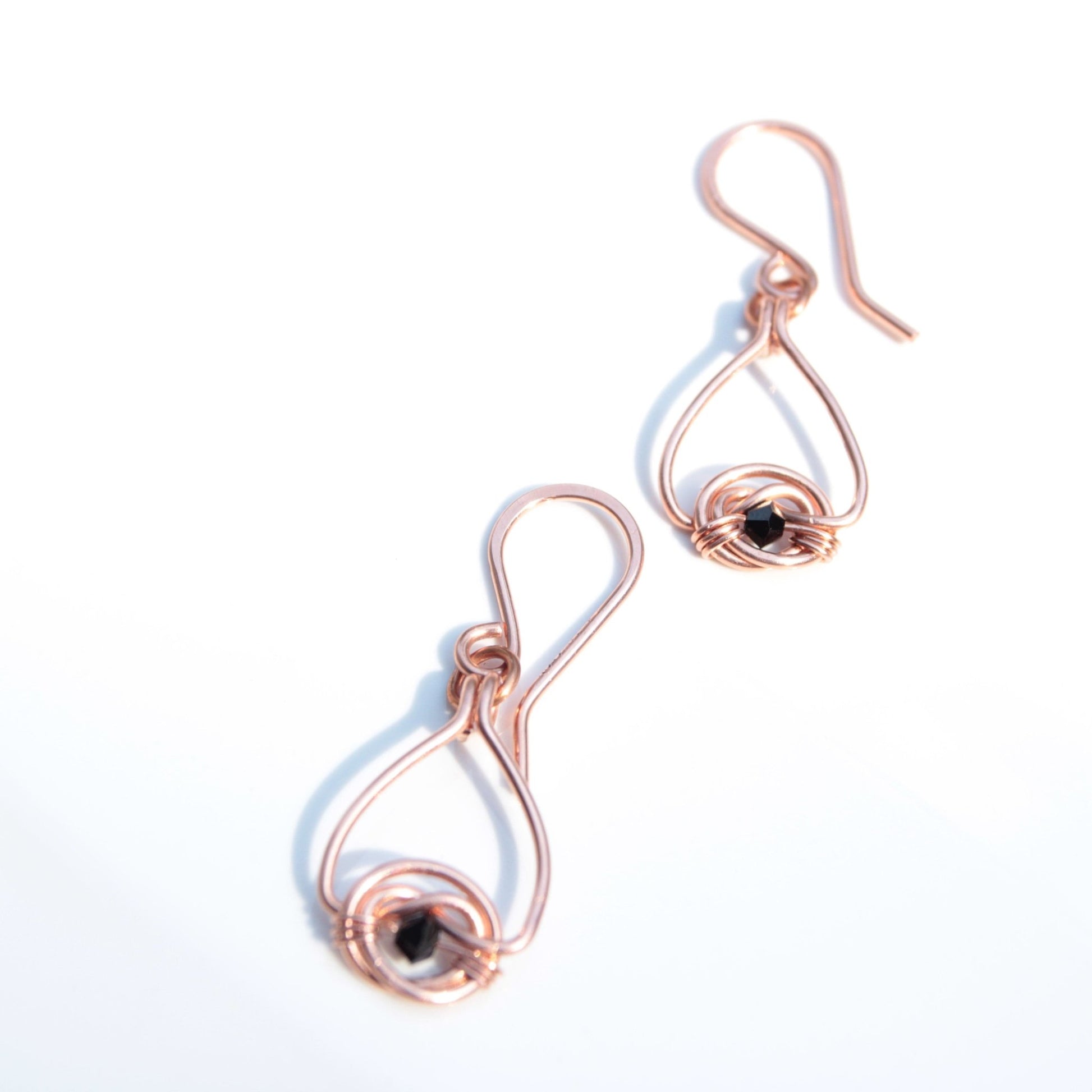 Copper double coin knot dangle earrings with black onyx beads hand made in USA Carrie Foscato design