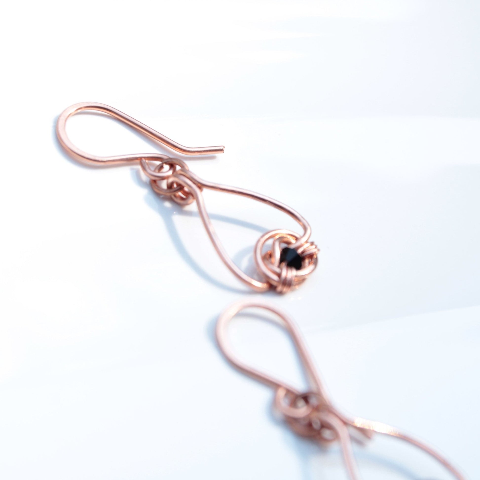 Copper double coin knot dangle earrings with black onyx beads hand made in USA Carrie Foscato design