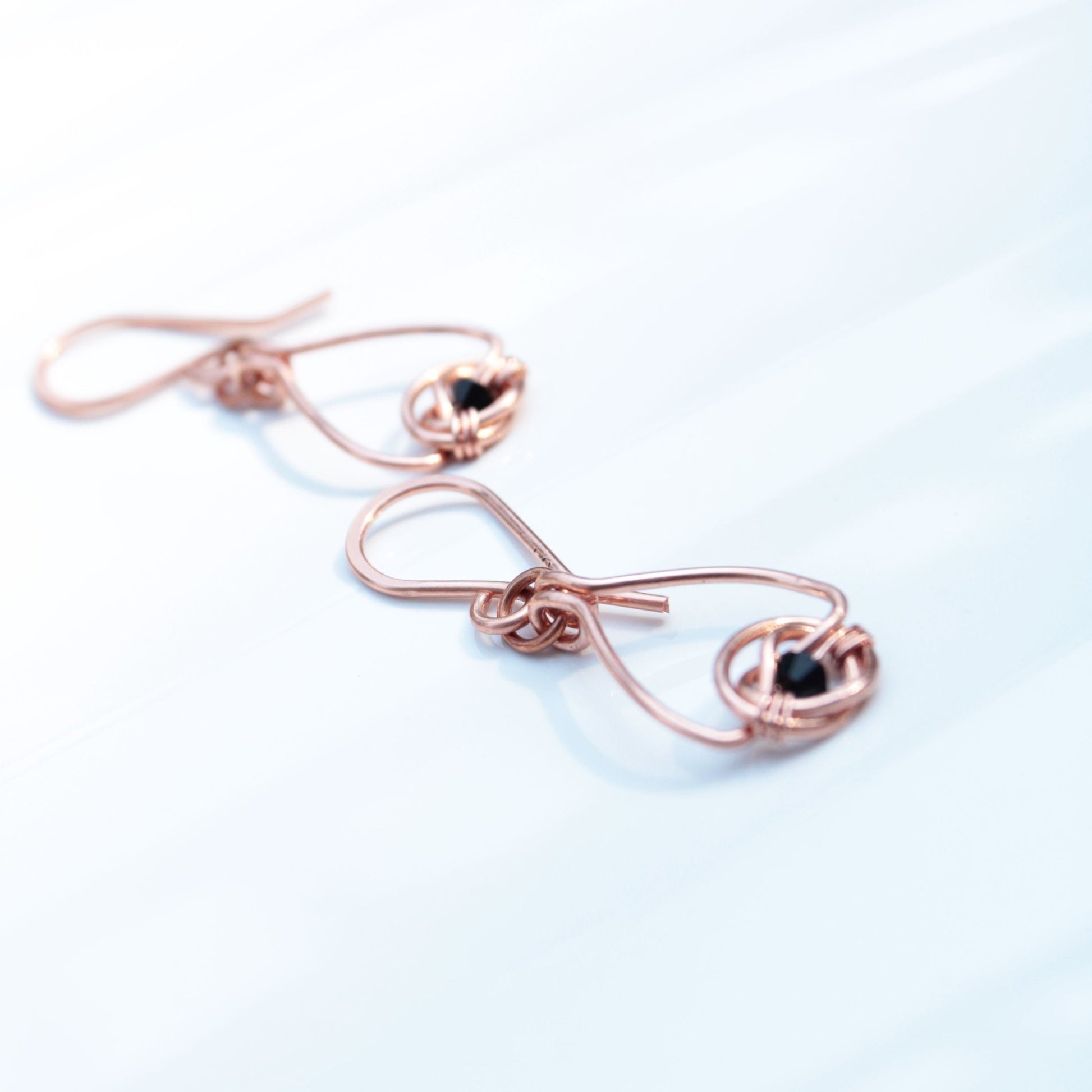 Copper double coin knot dangle earrings with black onyx beads hand made in USA Carrie Foscato design