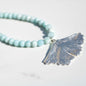 handmade fine silver ginkgo leaf pendant on a strand of aquamarine 8mm beads fasted with a sterling silver toggle clasp carrie foscato design made in USA