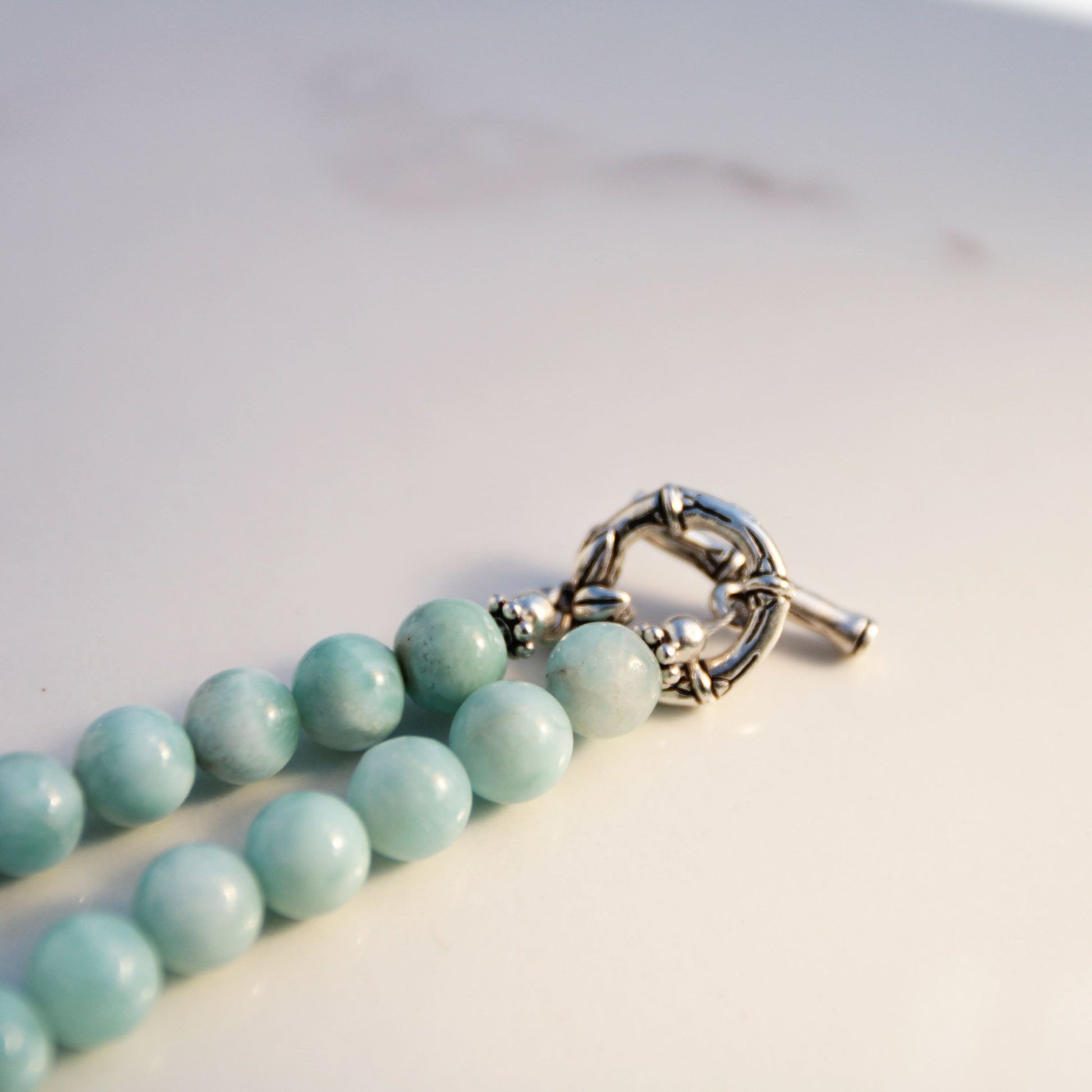 handmade fine silver ginkgo leaf pendant on a strand of aquamarine 8mm beads fasted with a sterling silver toggle clasp carrie foscato design made in USA